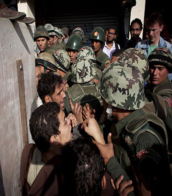 Egyptian protesters scuffle with army soldiers near the presidential palace in Cairo, Egypt. (AP)