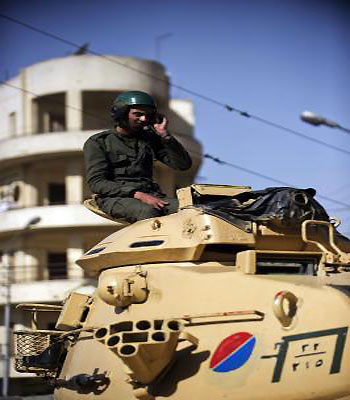 An Egyptian army soldiers sits on a tank deployed outside the presidential palace in Cairo on December 10, 2012. (AFP)
