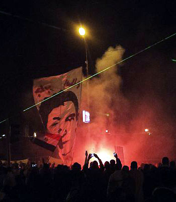 Protesters light up a flair as thousands of Egyptian opposition supporters rally outside of the Presidential palace to protest against the upcoming referendum on the new draft constitution, in Cairo. (AFP)