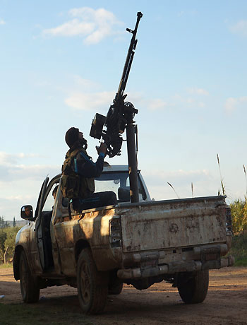 A Free Syrian Army fighter aims his weapon towards a Syrian military warplane, in Aleppo's al-Amereya district. (Reuters)