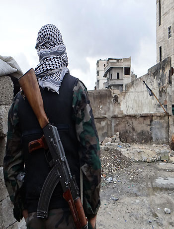 A Free Syrian Army fighter takes position in Aleppo's al-Amereya district December 11, 2012. (Reuters)