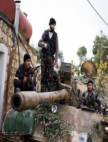 Kurdish members of the FSA are seen on a tank stolen from the Syrian Army in Fafeen village, north of Aleppo province, Syria, Wednesday, Dec 12, 2012. (AP)