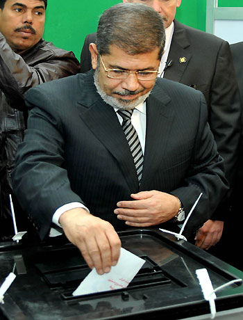 In this image released by the Egyptian Presidency, President Mohammed Morsi casts his vote at a polling station during a referendum on a disputed constitution, Cairo, Egypt, Saturday, Dec. 15, 2012. (AFP)