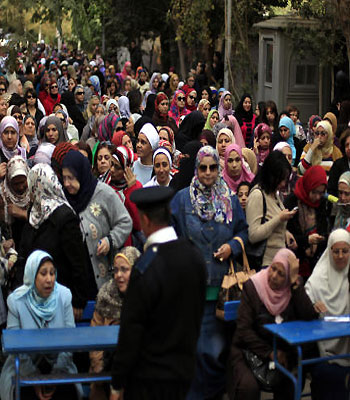 Egyptian women line up outside a polling station to cast their votes during a referendum on a disputed constitution drafted by Islamist supporters of President Mursi in Cairo, Egypt. (AP)