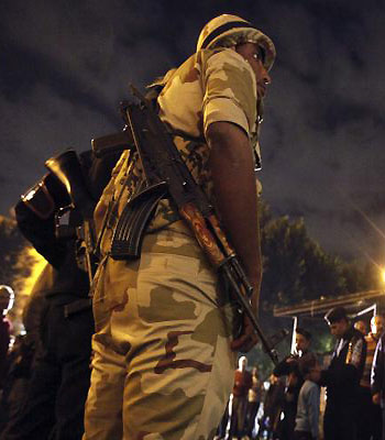 A soldier tries to control a queue outside a polling centre waiting to vote in referendum on Egypt's new constitution in Cairo. (R)