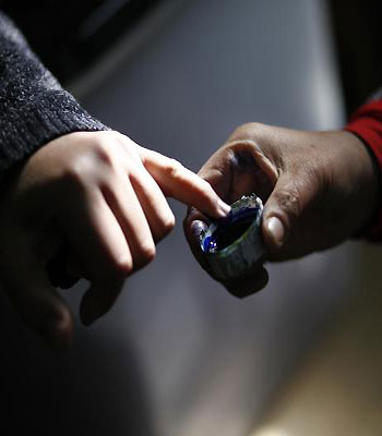 An Egyptian man dips his finger in ink after casting his vote in a referendum on a new constitution at a polling station in central Cairo. (AFP)