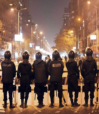 Egyptian riot police cordon off all access to the road leading to the police station in Cairo's Doqqi neighbourhood on December 16, 2012. (AFP)