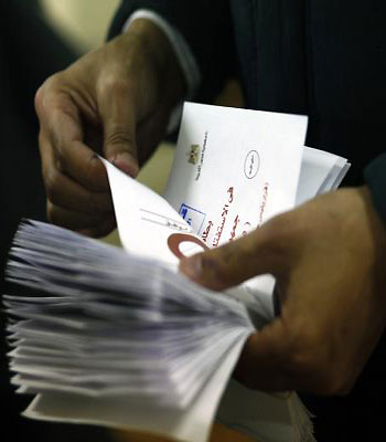 Polling station officials count ballots in Cairo on December 15, 2012 at the end of the first day of vote in a referendum on a new constitution. (AFP)