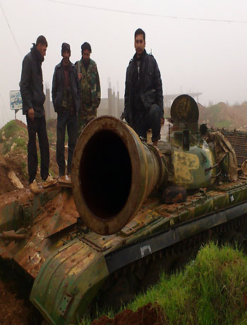 Free Syrian Army fighters from Al-Farooq battalion pose atop damaged tanks after the fighters said they fought and defeated government troops in Halfaya, near Hama December 18, 2012. (Reuters)