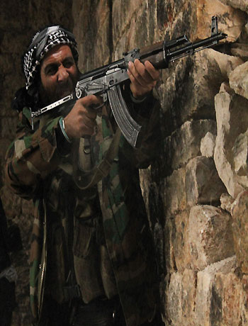 Free Syrian Army fighters take their positions as one of them fires during clashes with forces loyal to Syria's President Bashar al-Assad in Qastal Harami area in Aleppo in this picture released December 19, 2012. (Reuters)