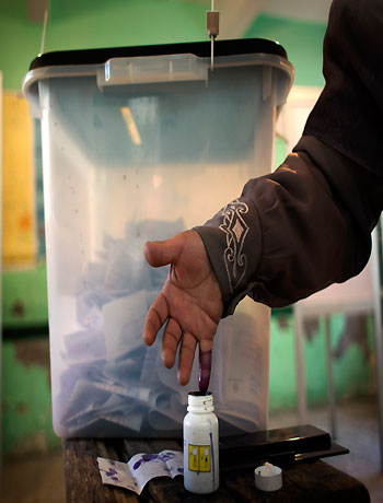 An Egyptian woman ink stains her finger after voting at a polling station during the second round of a referendum on a disputed constitution drafted by Islamist supporters of President Mohammed Morsi, in Giza, Egypt, Saturday, Dec. 22, 2012. (AP)