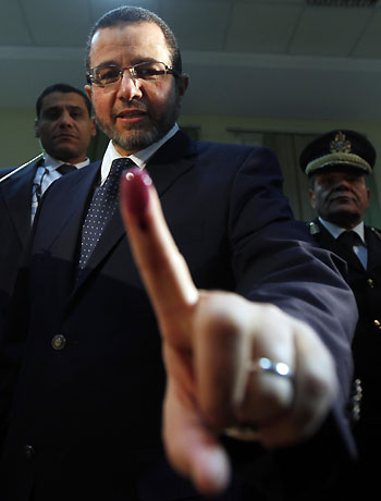 Egypt's Prime Minister Hisham Qandil shows his ink-stained finger after casting his vote in the final stage of a referendum on Egypt's new constitution in El Dokki district of greater Giza, south of Cairo, December 22, 2012. (Reuters)