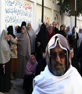 Women queue outside a polling centre to vote during the final stage of a referendum on Egypt's new constitution in Bani Sweif. (R)