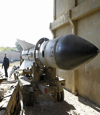 A man walks near a missile at the barracks of the Syrian Army's 150th regiment after its fallen into the hands of the Free Syrian Army in Rif Damascus. (R)