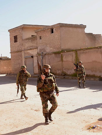 Soldiers loyal to Syrian President Bashar al-Assad patrol the streets in a town in Aleppo province December 27, 2012. (Reuters)