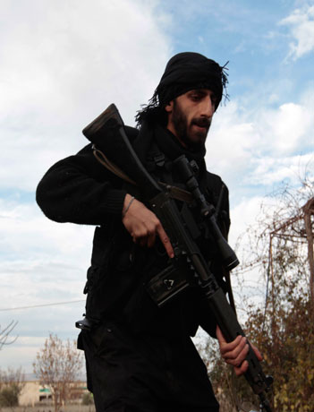 A Free Syrian Army fighter runs as he participates in seizing Menagh military airport in north Aleppo December 28, 2012. (Reuters)