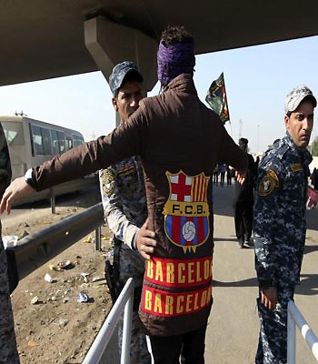Iraqi policemen search Shi'ite pilgrims as they walk to the holy city of Kerbala to mark Arbain in Baghdad. (R)