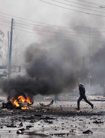 In this Dec. 17, 2012 file photo, a man runs between debris after a mortar shell hit a street killing several people in the Bustan Al-Qasr district of Aleppo, Syria. (AP)