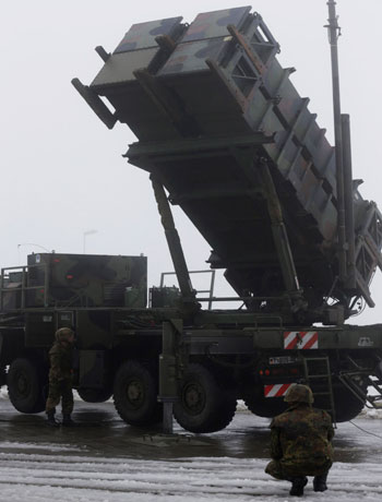 Soldiers of the German armed forces Bundeswehr stand next to a PAC-2 launcher of a "Patriot" missile battery during a media rehearsal in the north German village of Warbelow December 18, 2012. (Reuters)