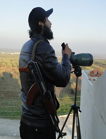 A Free Syrian Army fighter uses binoculars to locate an over-flying jet near the Menagh military airport, in Aleppo's countryside January 3, 2013. (Reuters)