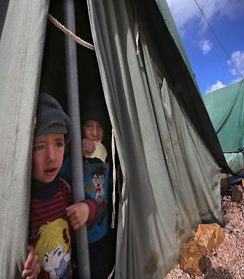 Syrian refugee boys look outside their tent, at a temporary refugee camp in the eastern Lebanese town of Marj near the border with Syria, Lebanon. (AP)