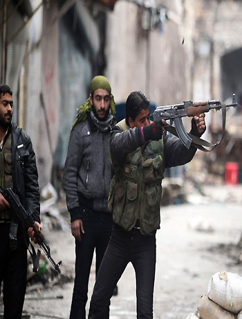 A Free Syrian Army fighter fires his weapon towards positions occupied by forces loyal to Syria's President Bashar al-Assad in the old city of Aleppo January 7, 2013. (Reuters)