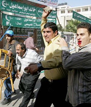 Supporters of the Muslim Brotherhood throw rocks at National Democratic Party supporters during a brawl at a voting station in the Raml district in the port city of Alexandria, during the second round of the Egyptian parliamentary elections (AFP)