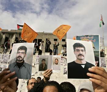 Families of jailed Palestinian prisoners in Israel hold pictures of their sons during protest in Gaza (R)