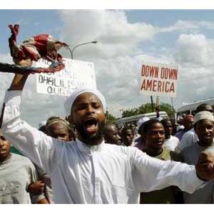 Tanzanian Muslim protesters chant anti US slogans while holding placards 'Down With America' during a demonstration in Dar es Salaam, Tanzania (AP)