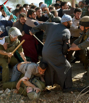 Palestinian demonstrators scuffle with Israeli soldiers and border police during a demonstration against the construction of Israel's separation barrier on the outskirts of the West Bank village of Abud, near Ramallah, Nov. 25, 2005 (AP)