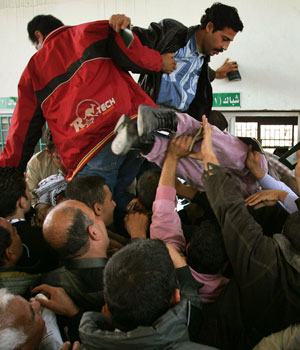 Palestinians, some jumping on top of others, rush to have their passports checked at the passport control terminal of the Rafah border crossing between the Gaza Strip and Egypt on Saturday Nov. 26, 2005 (AP)