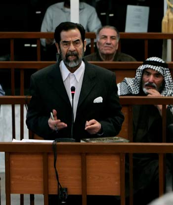 Iraqi dictator Saddam Hussein gestures as speaks to presiding Judge Rizgar Mohammed Amin during his trial (AFP)