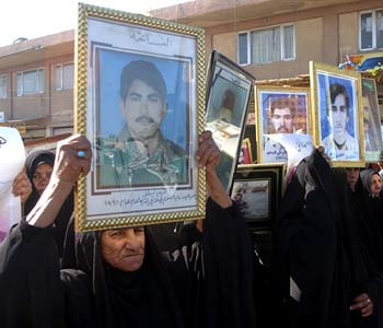 Iraqi women hold pictures of their relatives during a demonstration asking for the death penalty for ousted dictator Saddam Hussein (AP)