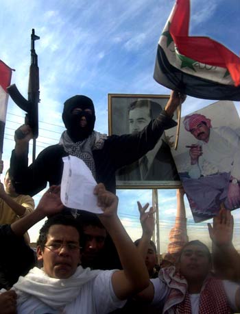 An armed Iraqi militant chants slogans in support of ousted Iraqi dictator Saddam Hussein during a demonstration in the village al-Awja (AFP)