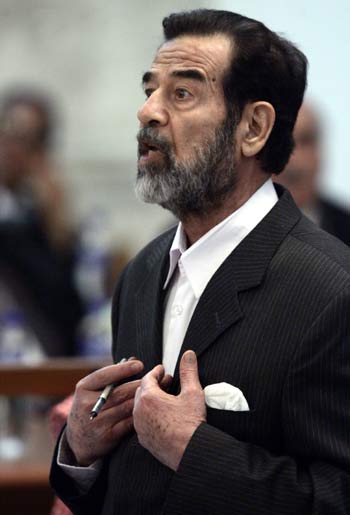 Former Iraqi president Saddam Hussein speaks to Presiding Judge Rizgar Mohammed Amin in Baghdad (AFP)