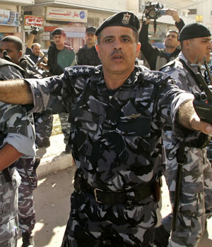 Palestinian policemen try to prevent members of al-Aqsa Martyrs Brigades from entering a government complex in Gaza, 1 December, 2005, (REUTERS)