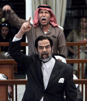 Former Iraqi President Saddam Hussein (front C) and Barzan Ibrahim al-Tikriti berates the court during their trial in Baghdad, 5 December, 2005 (EPA)