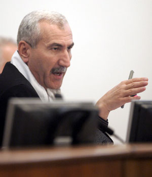 Presiding Judge Rizgar Mohammed Amin speaks to another judge on the tribunal during the trial of former Iraqi President Saddam Hussein and seven of his aides held under tight security in Baghdads heavily fortified Green Zone, December 6, 2005 (AP)