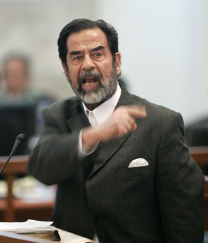Former Iraqi President Saddam Hussein gestures during his trial held under tight security in Baghdad's heavily fortified Green Zone, 06 December 2005 (AFP)