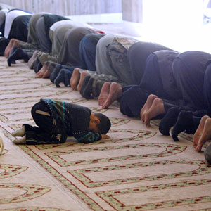 An Iraqi child joins Friday prayers with other residents at a mosque in central Baghdad December 9, 2005 (REUTERS)