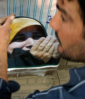 Iraqi resident looks at election posters urging people to vote in next week's parliamentary elections in central Baghdad (REUTERS)