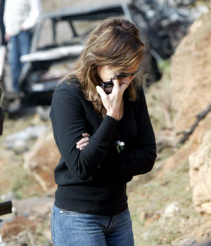 The wife of victim Lebanese journalist and MP Gibran Tueni cries at the scene of a car bomb explosion, killing at least three people, in Beirut's Mkalles Christian suburb which targeted Tueni who was killed immediately, according to eye witnesses (EPA)