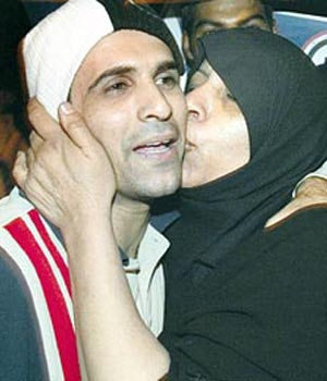 An Iraqi mother kisses her son who was detained in Lebanon and released after the intervention of Iyad Allawi in the run up to the elections (AP)