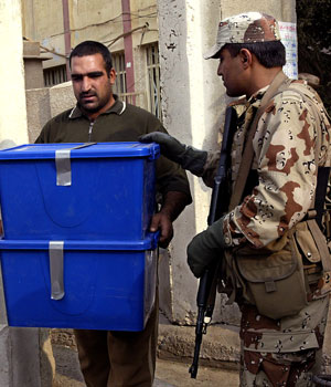 An employee of the Independent Electoral Commission in Iraq (IECI) takes out election material from a polling station in Baghdad to be transferred to the main headquarters of (IECI) in capital of the war-torn country (AFP)