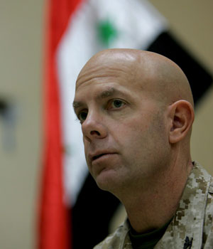 Backdropped by an Iraqi flag, Col. Dave Berger, commander of the US Marine Corps Regional Combat Team No. 8, comments on the security and rehabilitation situation in Fallujah, 20 December 2005 (EPA)
