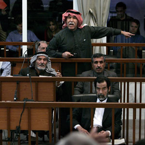 The half-brother of former Iraqi President Saddam Hussein, Barzan Ibrahim al-Tikriti (back row, standing) speaks as Saddam's trial resumes in Baghdad, 21 December 2005 (EPA)