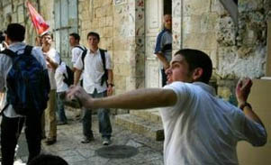 A member of the 'Temple Mount Faithful' hurls a stone after one of the group was hit by a bottle (AP)