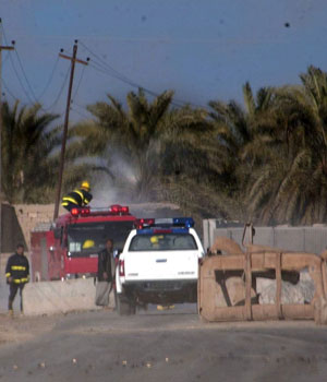 Iraqi firefighters and policemen gather at a checkpoint after an attack by gunmen in Baquba, north east of Baghdad, 26 December, 2005 (EPA)