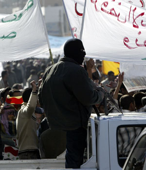 A masked Iraqi policeman stands on guard during a demonstration in central Baghdad December 27, 2005 (REUTERS)