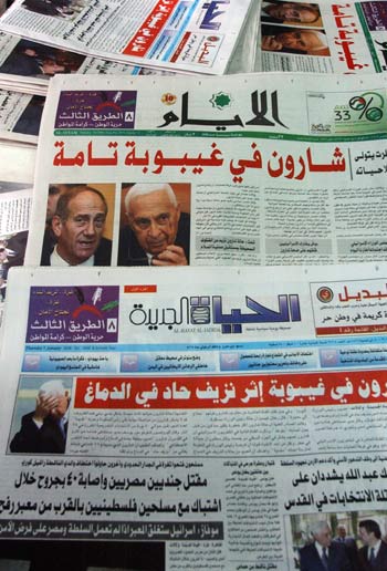 Palestinian newspapers in Arabic with headlines reading "Sharon is in a coma" (AP)